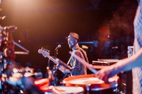 Guitarist playing on stage with crowd in background